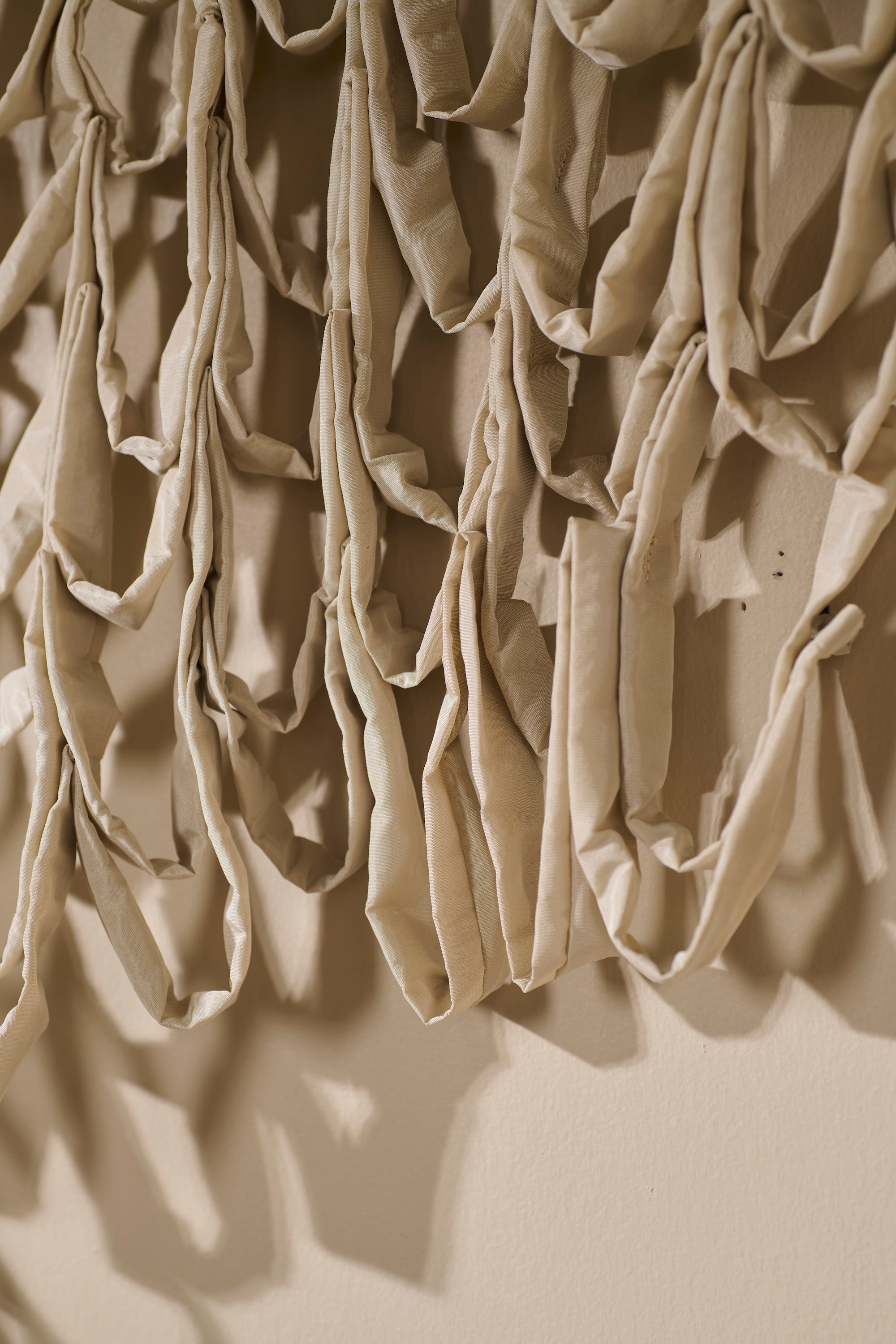 Close-up of Murmur 2 textile sculpture by Lauren HB Studio, showing hand-stitched loops and layered fabric construction. The photo highlights the craftsmanship and sculptural dimension of the piece’s woven, undulating pattern.