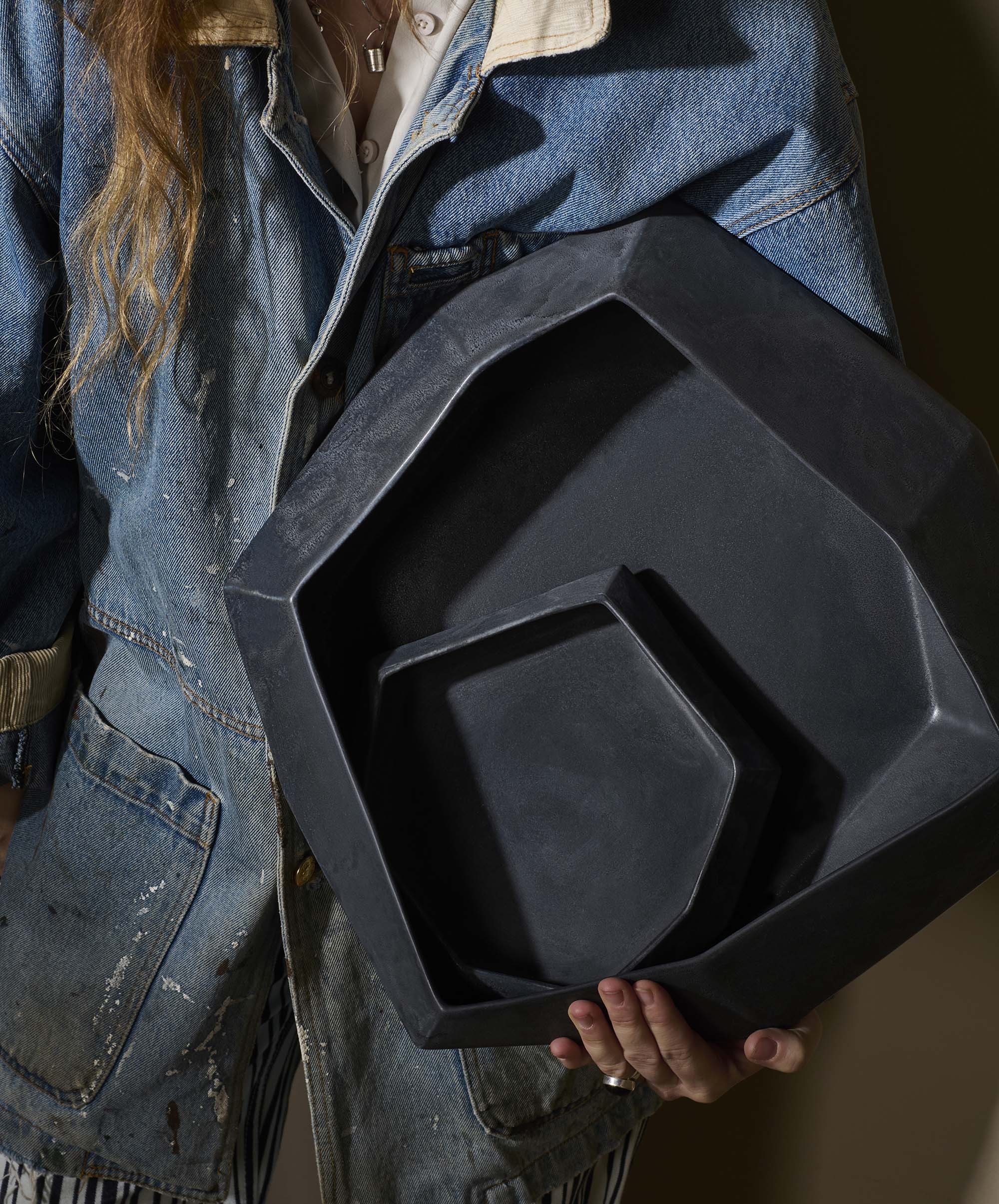 Women holding  in denim jacket holding two sizes of Nested Stone Bowl Set by Lauren HB Studio.