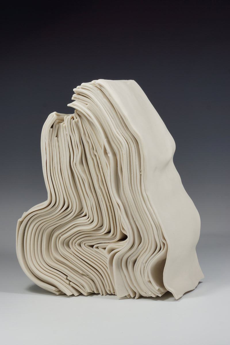 Folded porcelain sculpture “Stack” by Lauren HB Studio showcasing organic, layered forms in soft neutral tones.